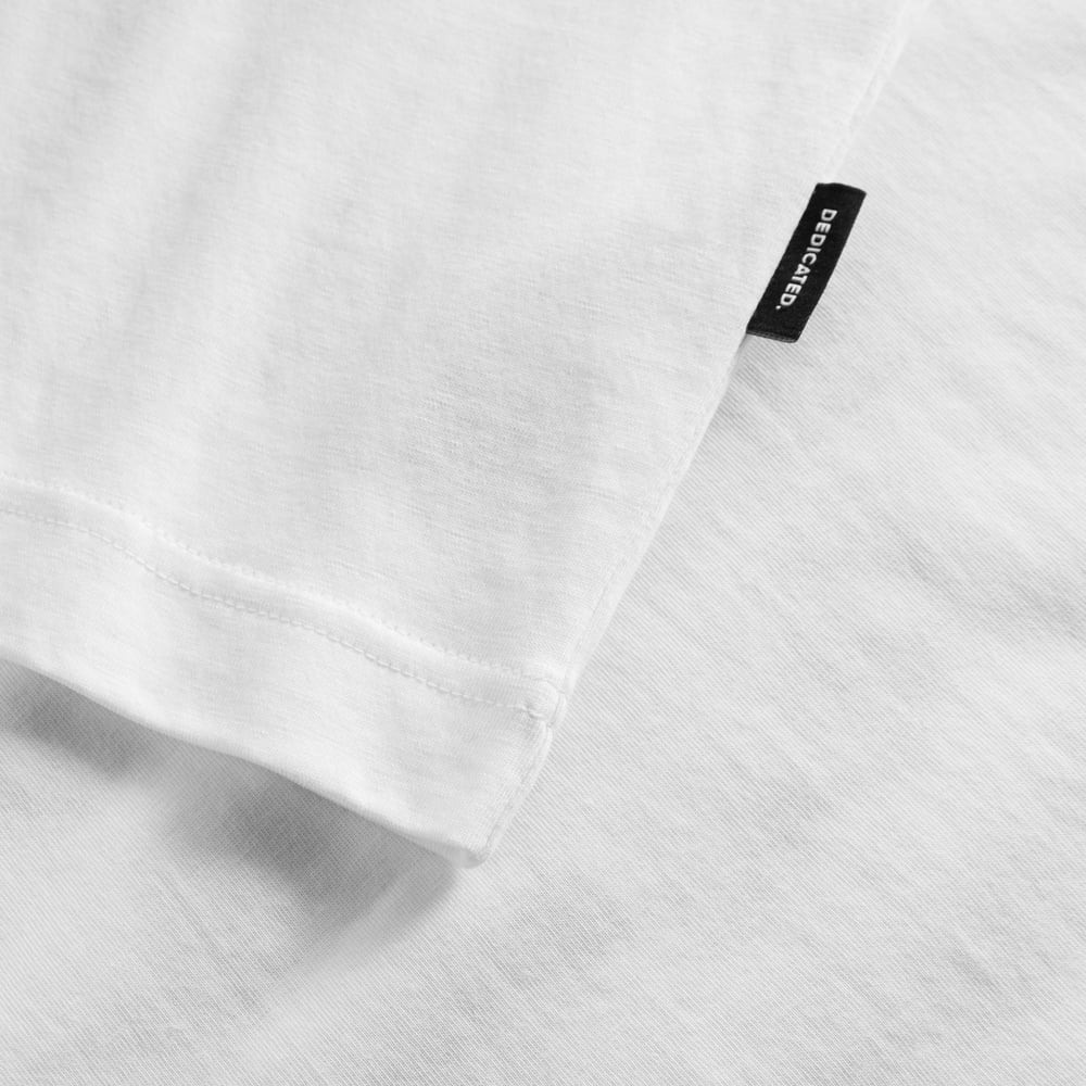 Close-up of the T-shirt Vadstena Dancing Man in white, showing the fabric, sleeve hem and small black Dedicated brand tag.