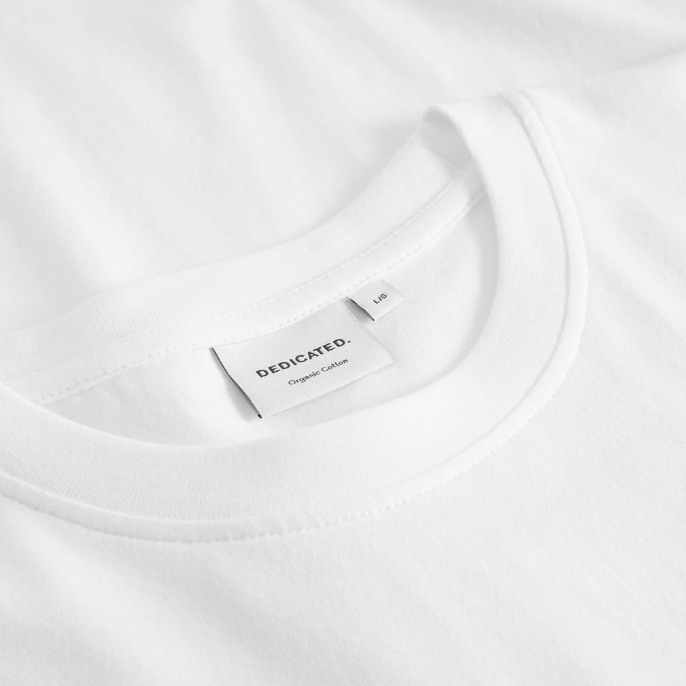 Nahaufnahme des Kragens und Markenetiketts des weißen T-Shirts Stockholm Pour Some White aus Bio-Baumwolle.