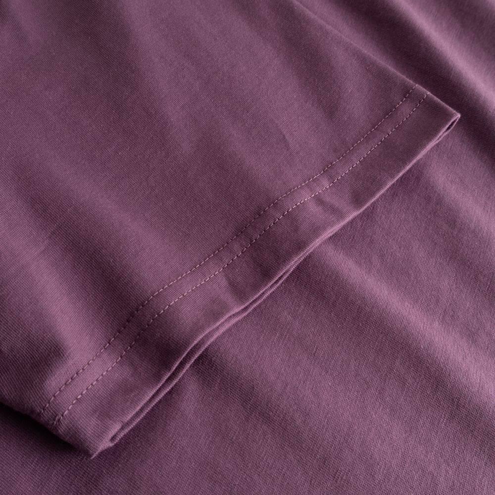 Närbild på ärmen på T-shirt Stockholm Base Berry Purple, som visar tygets struktur och sömmar.