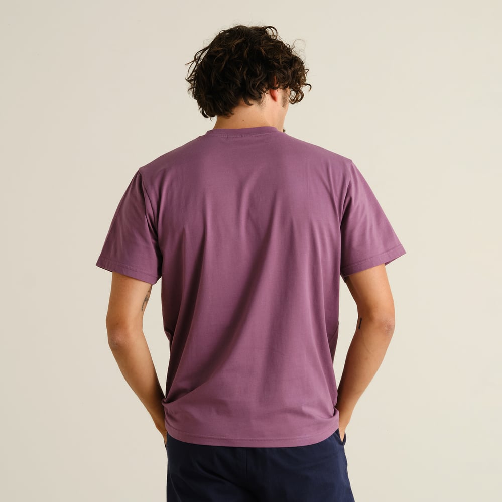 Man sedd bakifrån, klädd i T-shirten Stockholm Base i färgen Berry Purple.