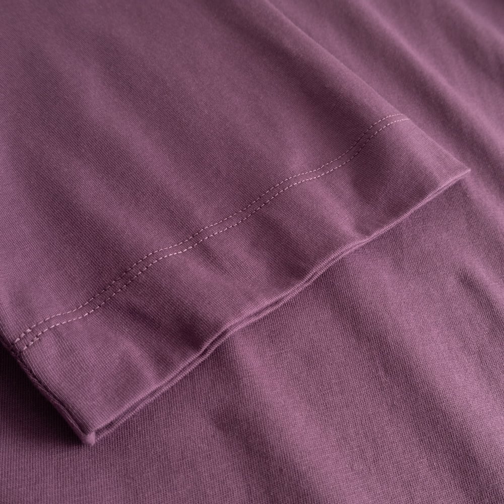 Close-up of the T-shirt Vadstena Base in Berry Purple, showing the soft fabric and stitching on the sleeve.