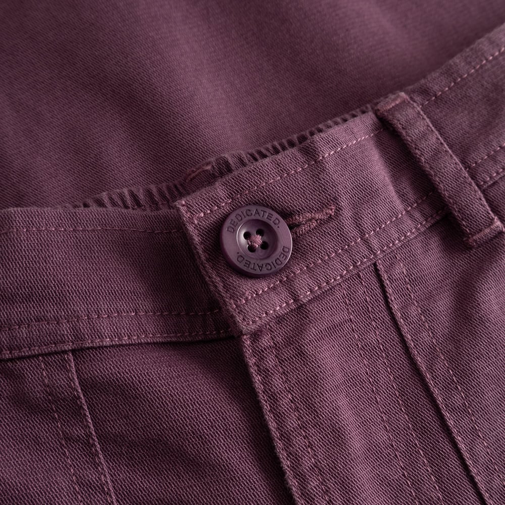 Detaljbild på Workwear Pants Vara i Berry Purple som visar dobby ripstop-tyget och den specialdesignade Dedicated-knappen.