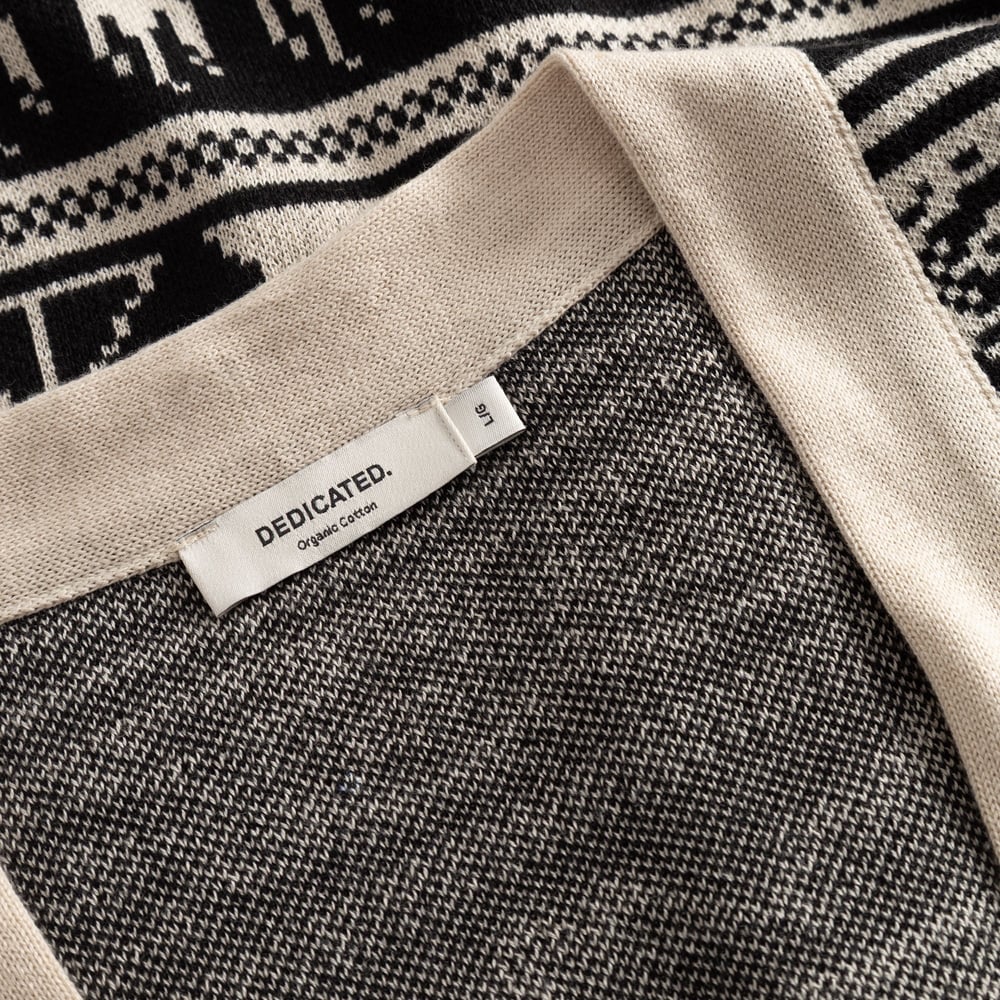 A close-up of the Cardigan Delsbo Fairsle Hike, showing the inner brand label and the intricate black jacquard knit pattern.