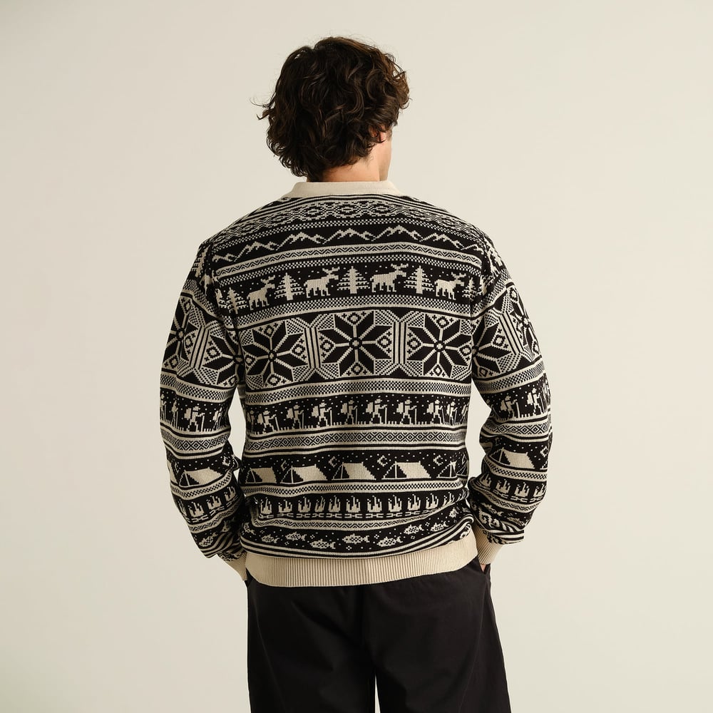 The Cardigan Delsbo Fairsle Hike Black, seen from behind on a model, revealing its fun and intricate jacquard pattern.