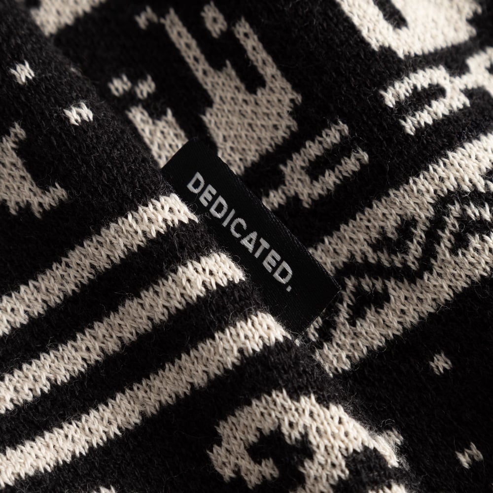 Close-up shot of the Cardigan Delsbo Fairsle Hike, detailing its jacquard knit pattern and the Dedicated brand label.