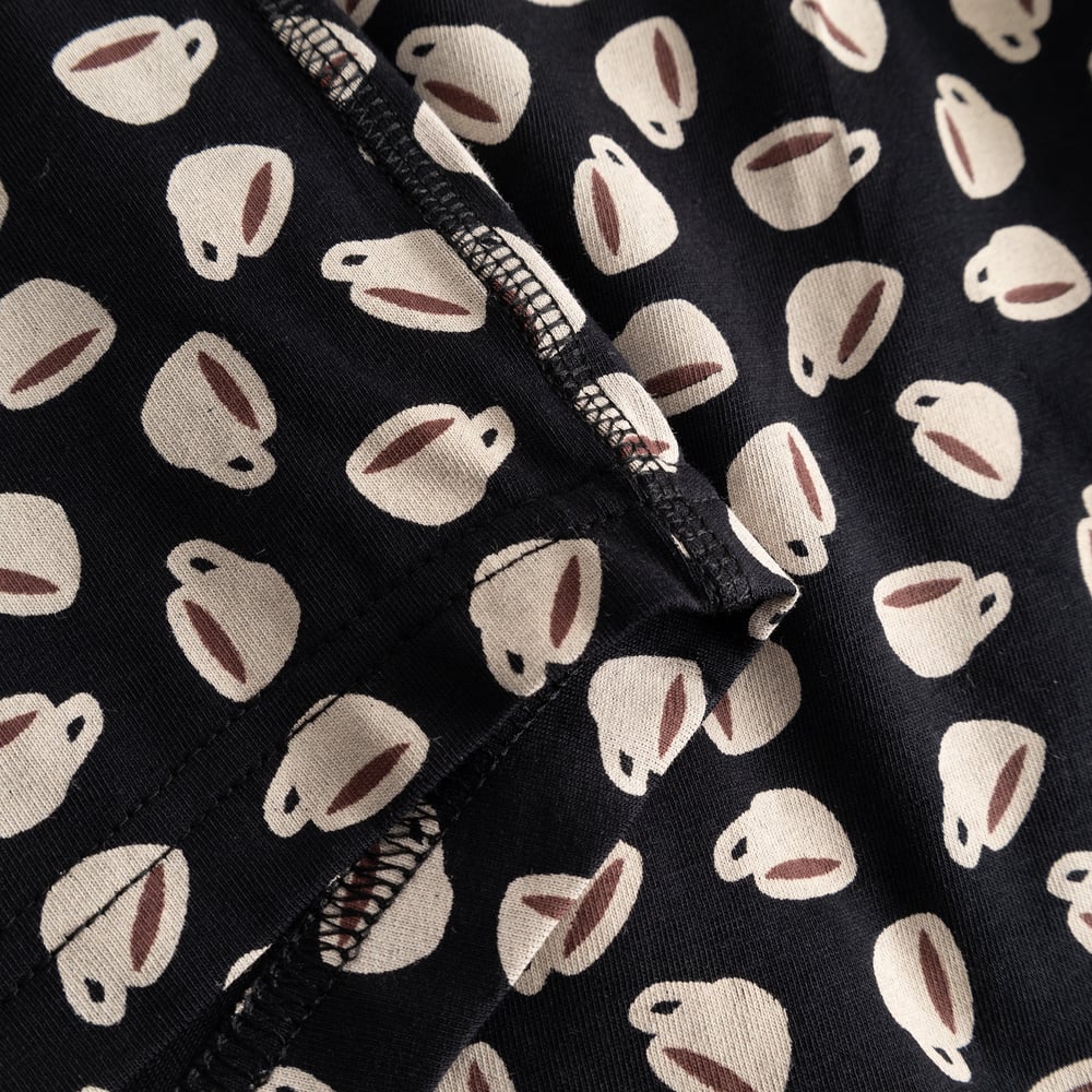 A close-up view of the Kalix Boxer Briefs in black, highlighting the charming all-over coffee cup print and fabric detail.