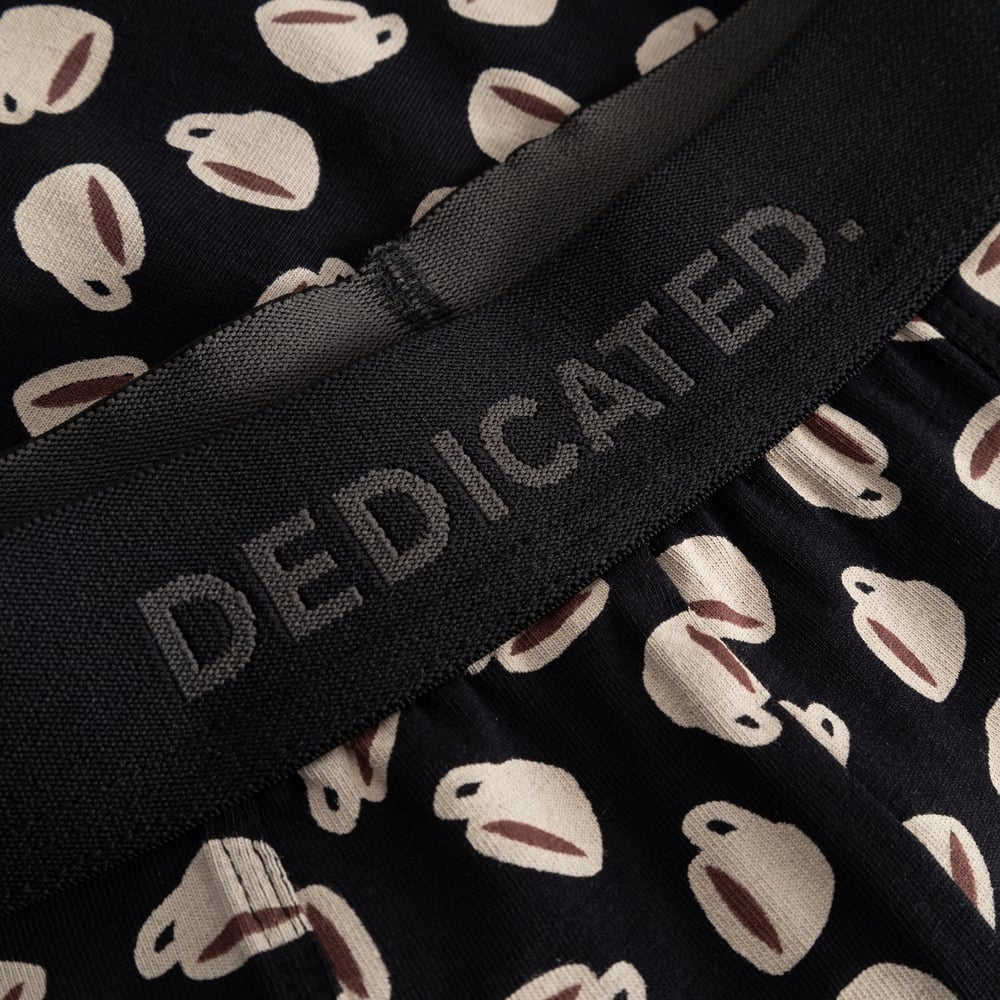 Detailed shot of the black Dedicated logo waistband on the Kalix boxer briefs with their fun coffee cup print.