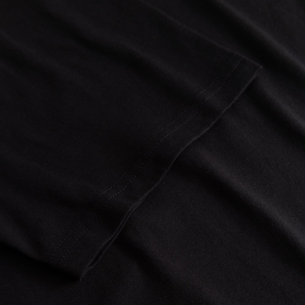 Close-up of the finely stitched sleeve on the T-shirt Stockholm My Imaginary Friends in black.