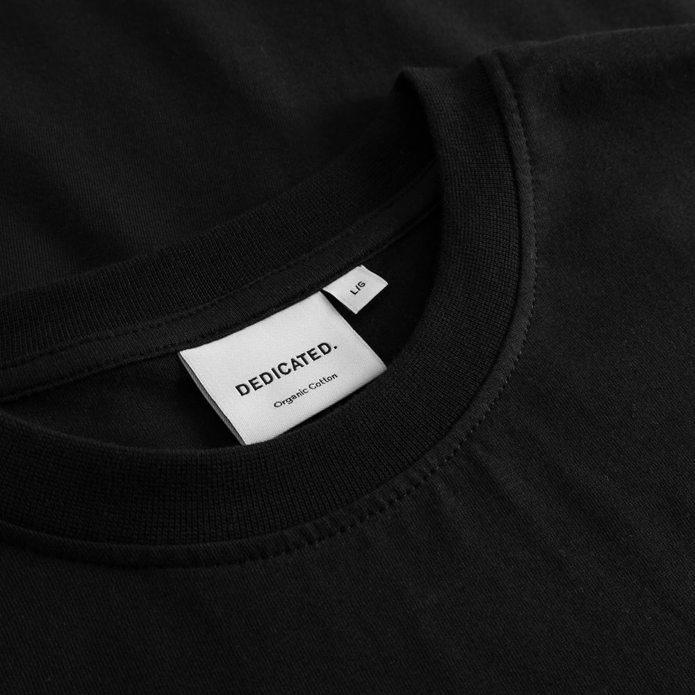 Detailaufnahme des gerippten Kragens und des Markenetiketts des T-Shirts Stockholm Life Black.