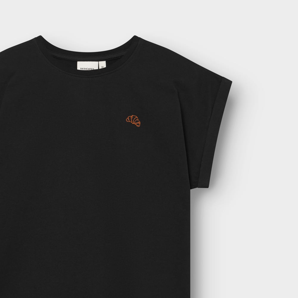 Close-up of the black T-shirt Visby Croissant, showing the neat orange embroidery, crew neck, and folded sleeve detail.