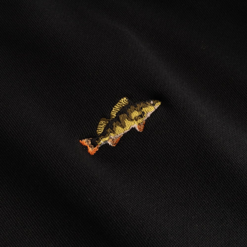 Close-up shot of the vibrant perch embroidery, a cool detail on the classic black Malmoe sweatshirt.