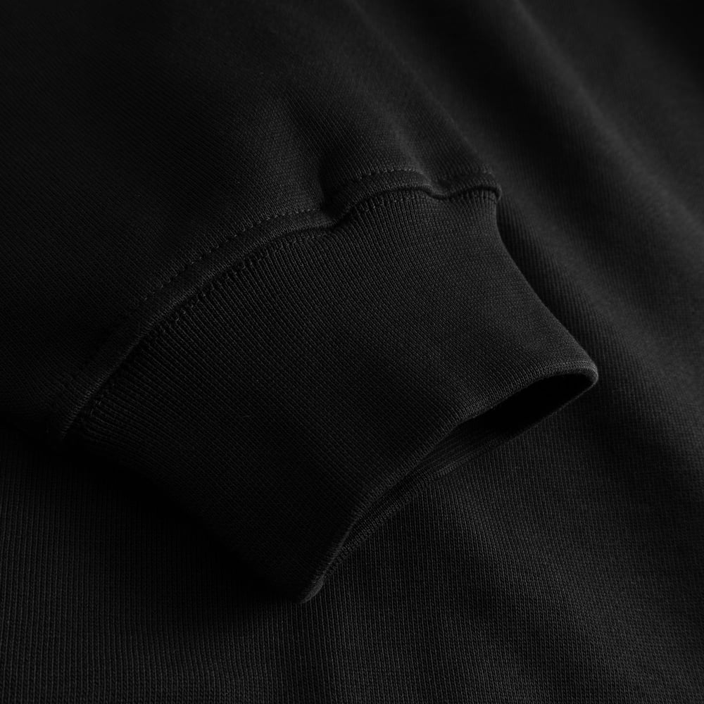 Close-up shot of the ribbed sleeve cuff on the black Hoodie Falun Cheers Salud.