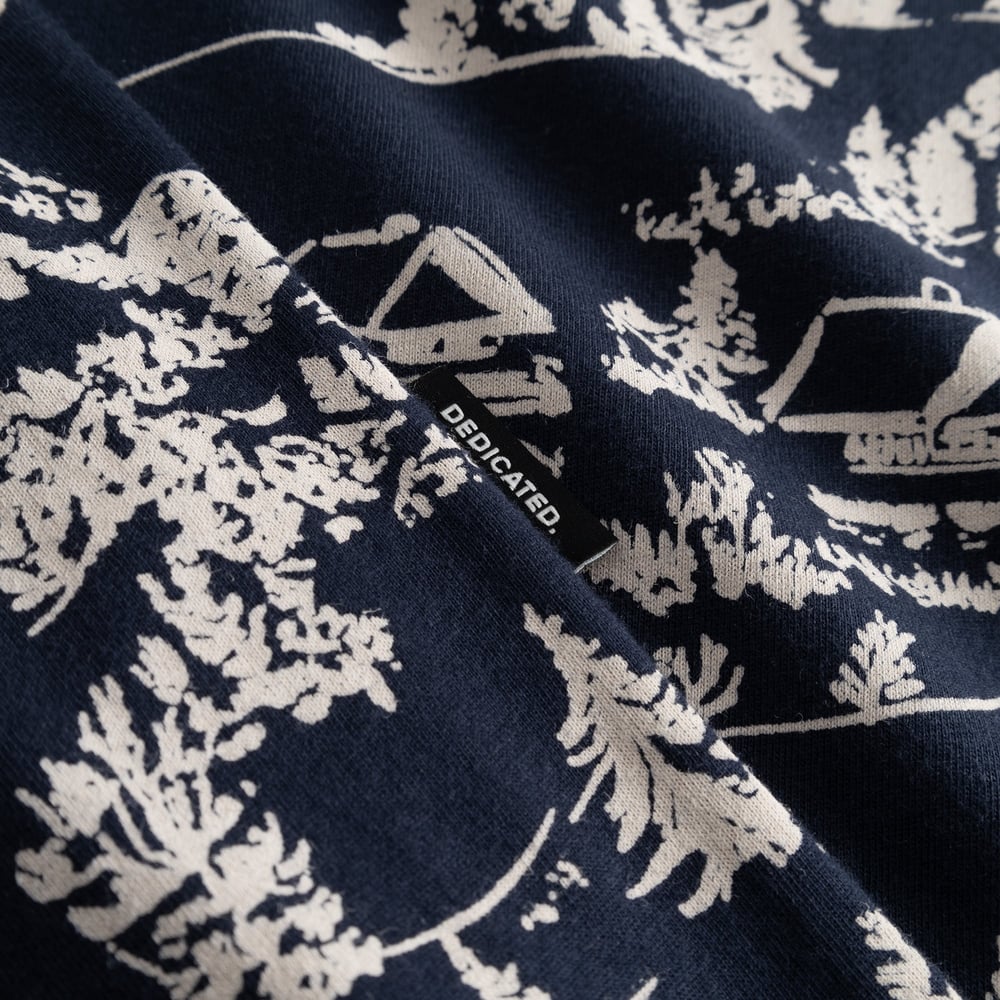Close-up of the navy T-shirt Stockholm, showing the Blue Hills all-over print and the small black Dedicated brand label.
