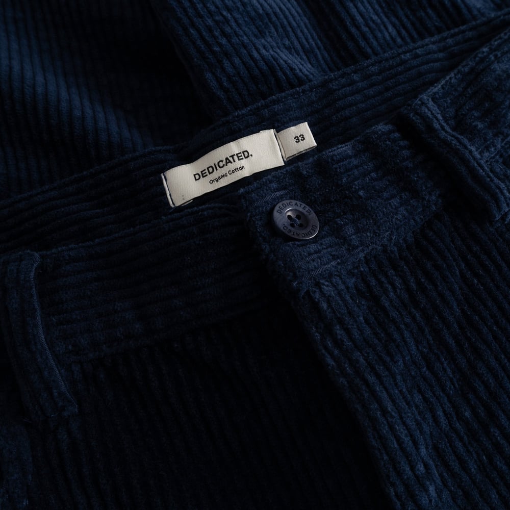 It's all in the details. A close-up of the navy corduroy fabric and branded waistband of our Pants Hamburg.