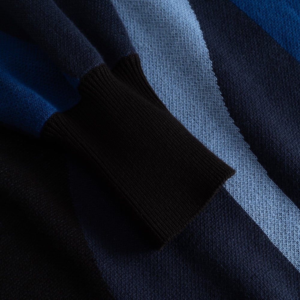 A close-up view of the jacquard knit sleeve of the Dress Nikkala, highlighting the dark ribbed cuff and wavy blue stripes.