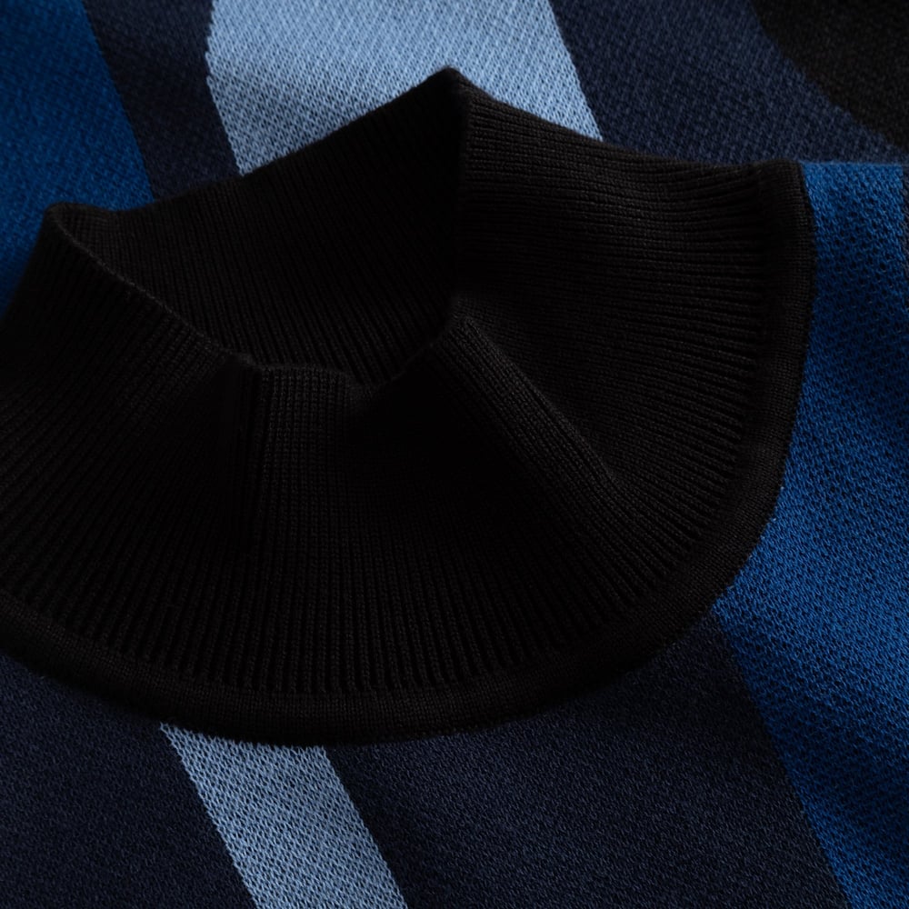 Close-up of the high ribbed collar on the Nikkala dress, showing the fine jacquard knit in wavy blue stripes.