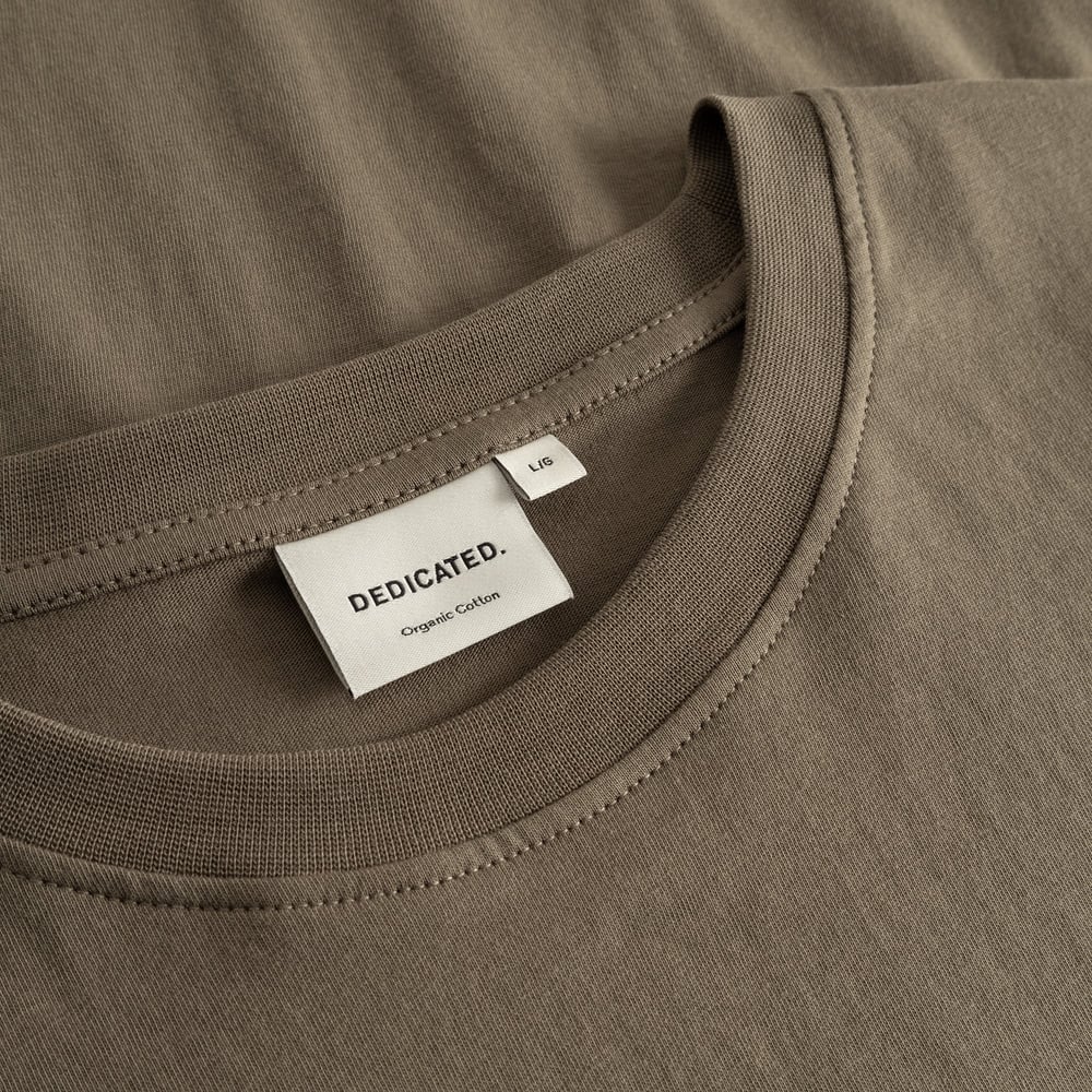A close-up of the T-shirt Stockholm in Bungee Green, showing the ribbed neckline and the Dedicated brand label.