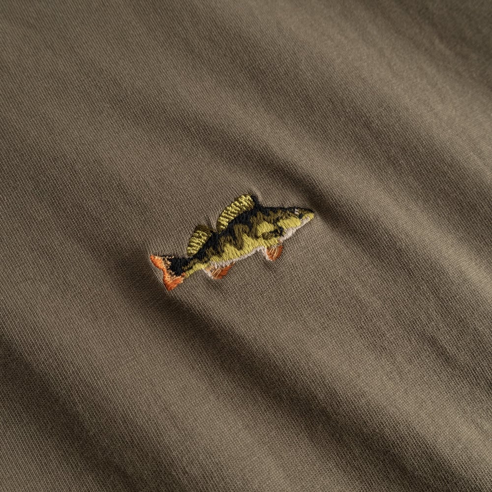 A detailed close-up of the perch fish embroidery on the T-shirt Stockholm in Bungee Green.