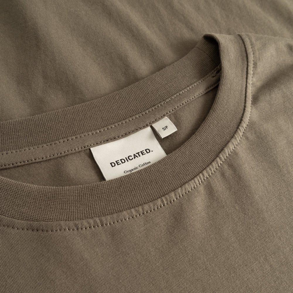 A detailed close-up of the ribbed crew neck and brand label on the T-shirt Vadstena Base in a versatile Bungee Green.
