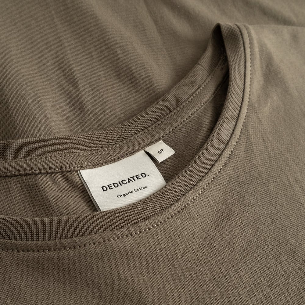 Detailed close-up of the ribbed neckline and brand label of the Dedicated T-shirt Visby Base Bungee Green.