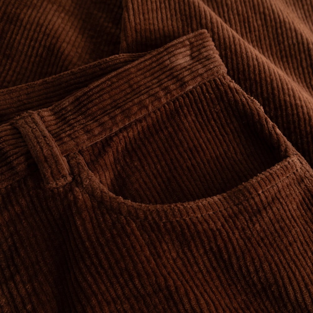A close-up view showcasing the warm, textured corduroy of the Hamburg Pants in a rich Cappuccino Brown.