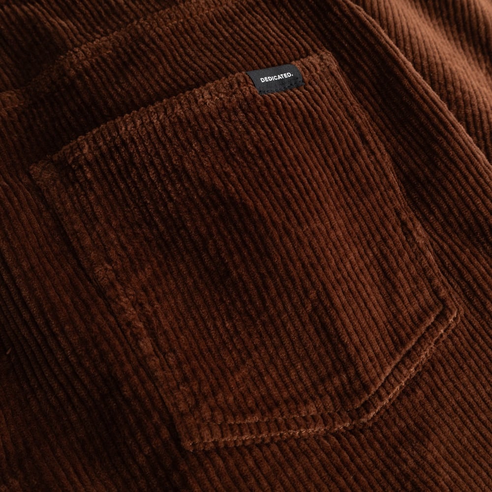 Close-up detail shot of the back pocket on the Pants Hamburg Corduroy Cappuccino Brown, showing the fabric and brand label.