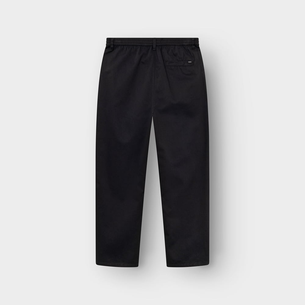 A flat lay of the Chino Pants Hudiksvall in black, showing the back view with its elastic waistband and single welt pocket.