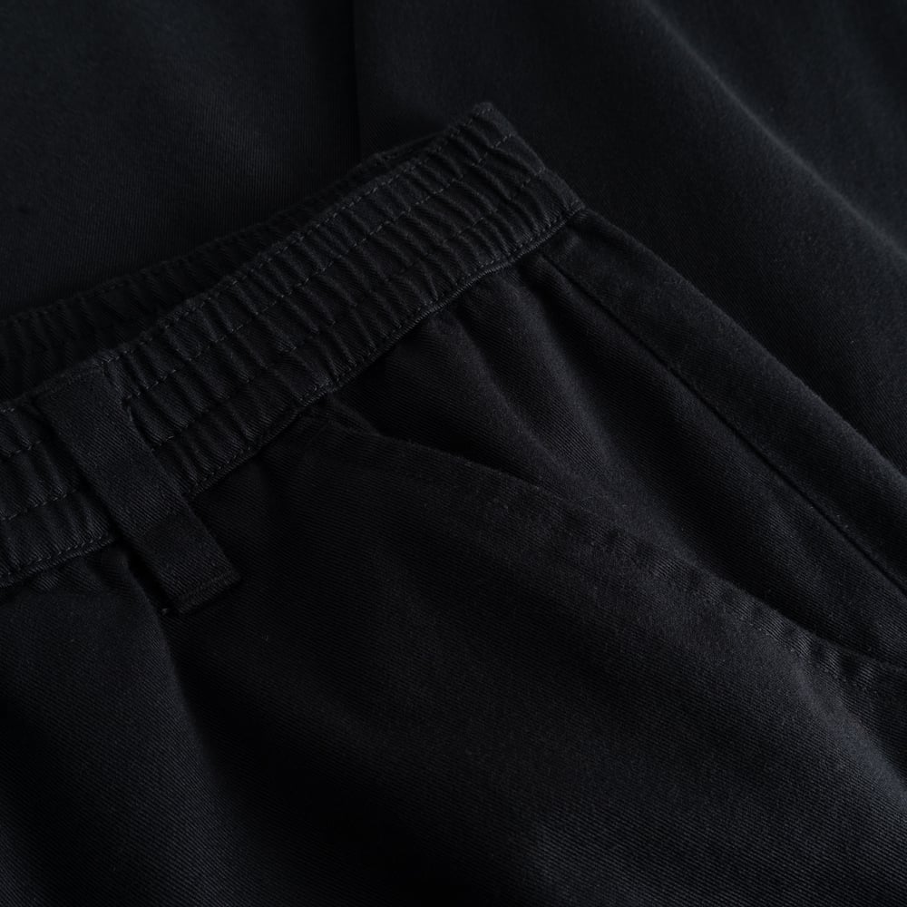 A detailed look at the elasticated waistband of the black Hudiksvall Chino Pants, crafted from organic cotton twill.