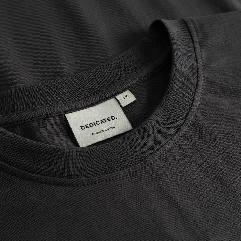 A close-up of the ribbed collar and woven brand label inside the charcoal T-shirt Stockholm Im Fashion.