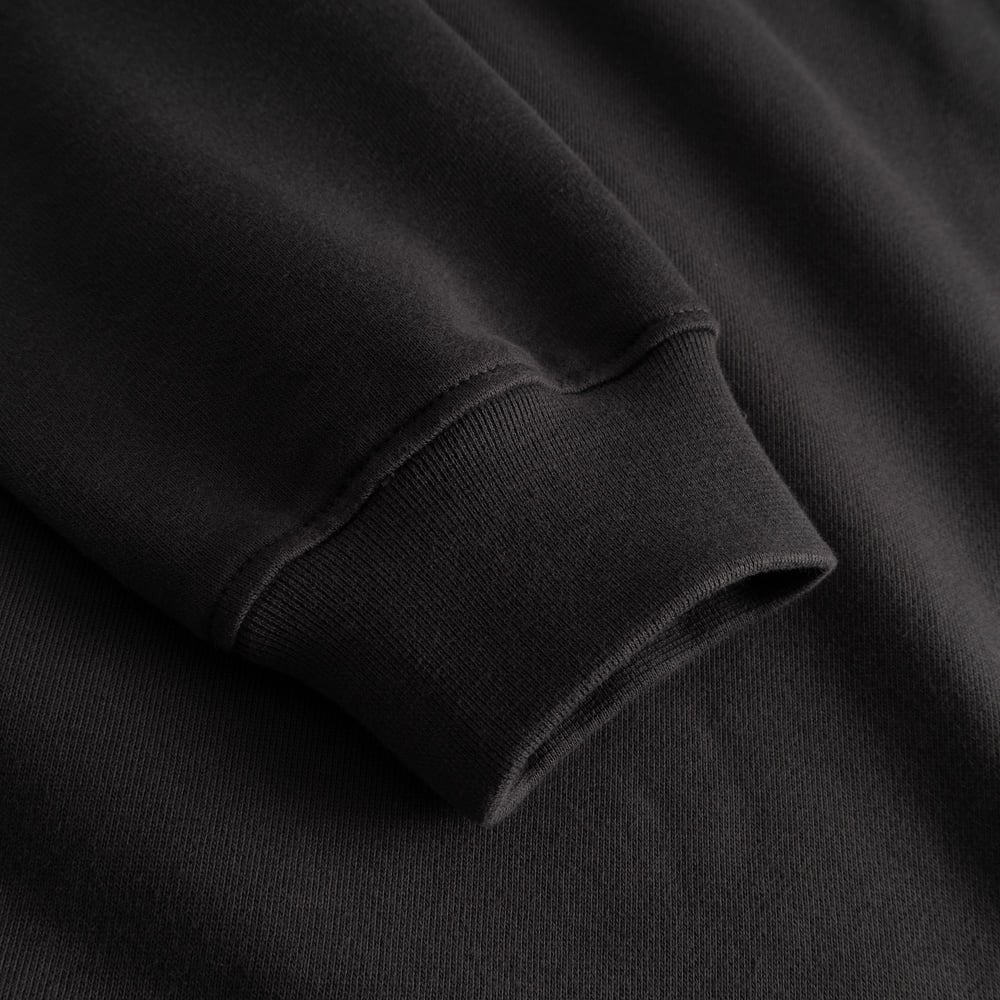 The comfortable ribbed cuff of the charcoal Ystad Painted Bird sweatshirt, shown in a detailed close-up.