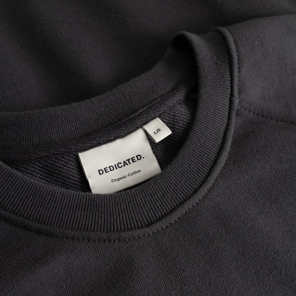 Close-up shot of the ribbed neckline and brand label on the charcoal Sweatshirt Malmoe Cheers Salud.
