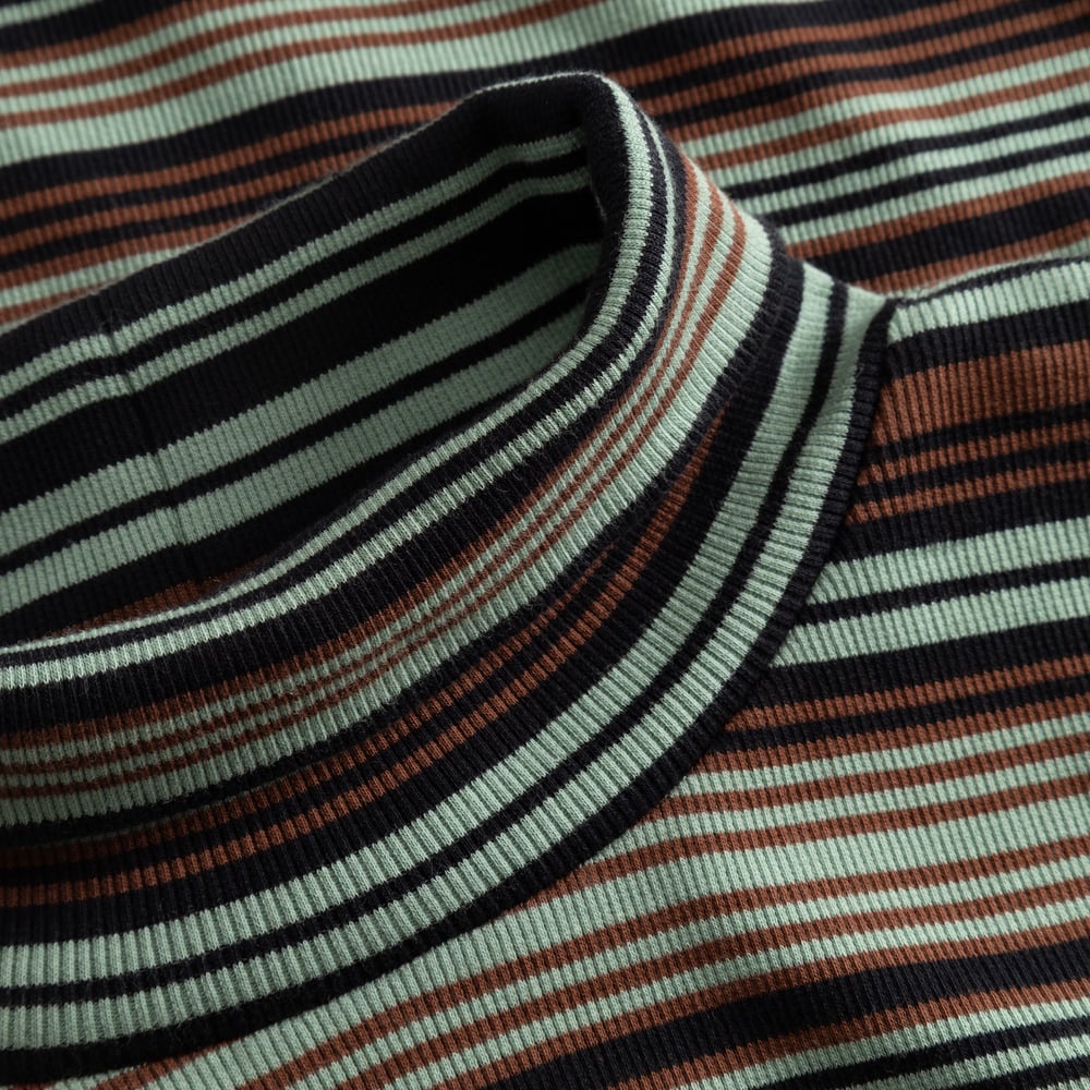 Close-up of the ribbed turtleneck on the Malma top, featuring irregular stripes in green, brown, and black.