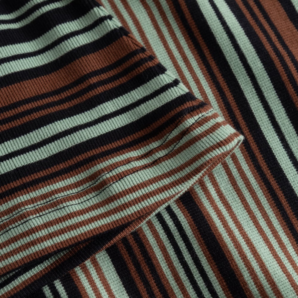 Close-up of the Rib Top Malma's soft, ribbed fabric, showing irregular stripes in mint green, rust brown, and black.