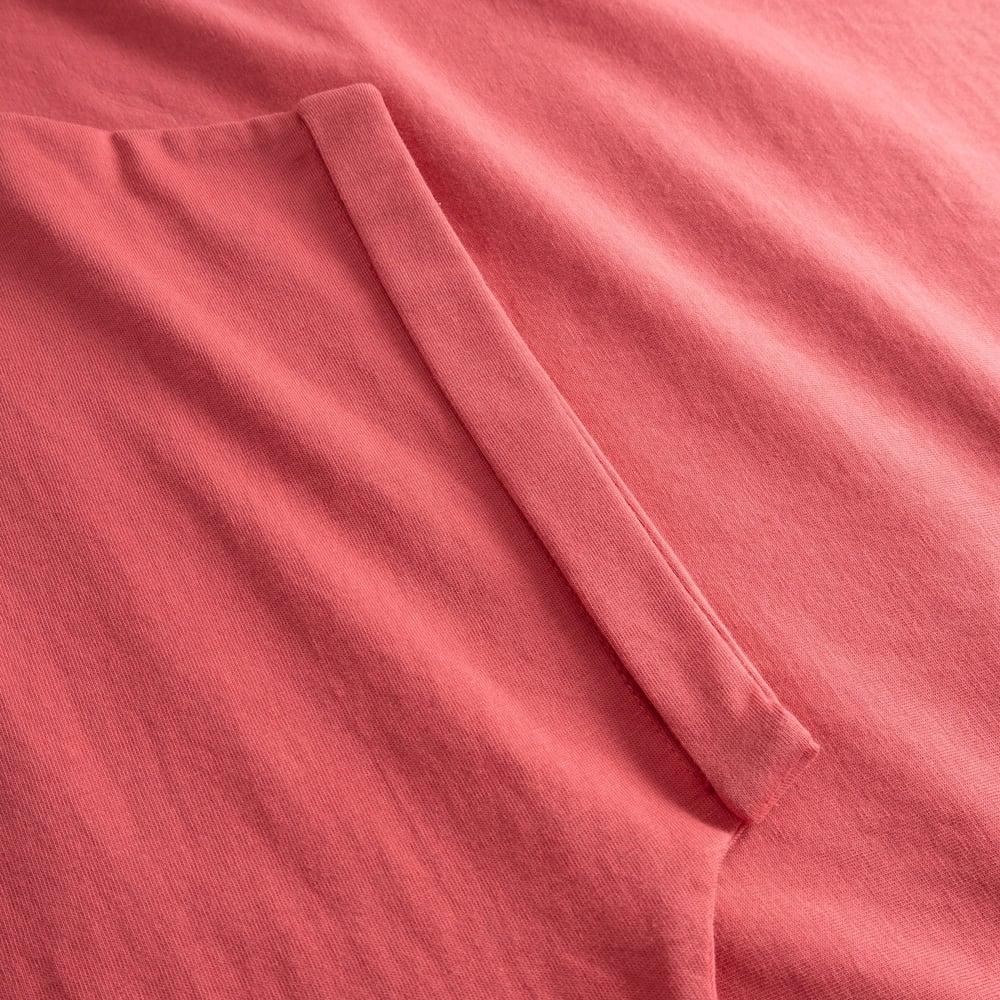A close-up of the soft, Holly Red organic cotton fabric on the T-shirt Visby Base, showing the neat folded sleeve detail.