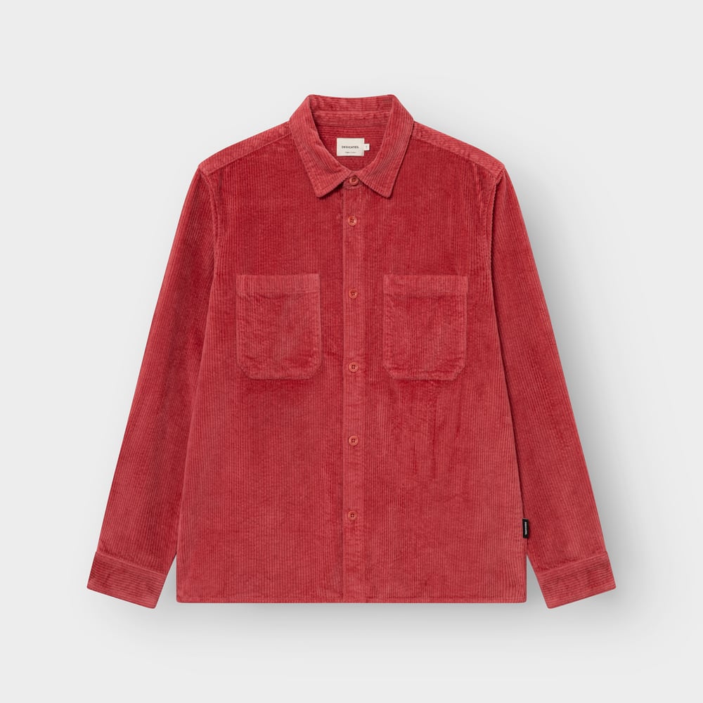 The Kil Corduroy Overshirt in Holly Red, shot flat to highlight its rich texture, dual chest pockets and relaxed fit.