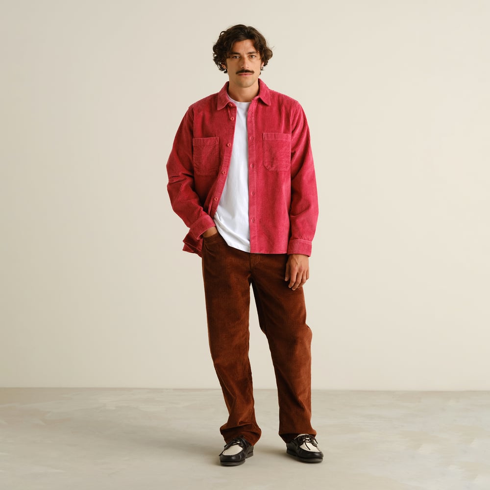 A model seen from the front, wearing the Shirt Kil Corduroy in Holly Red layered over a white t-shirt and brown pants.