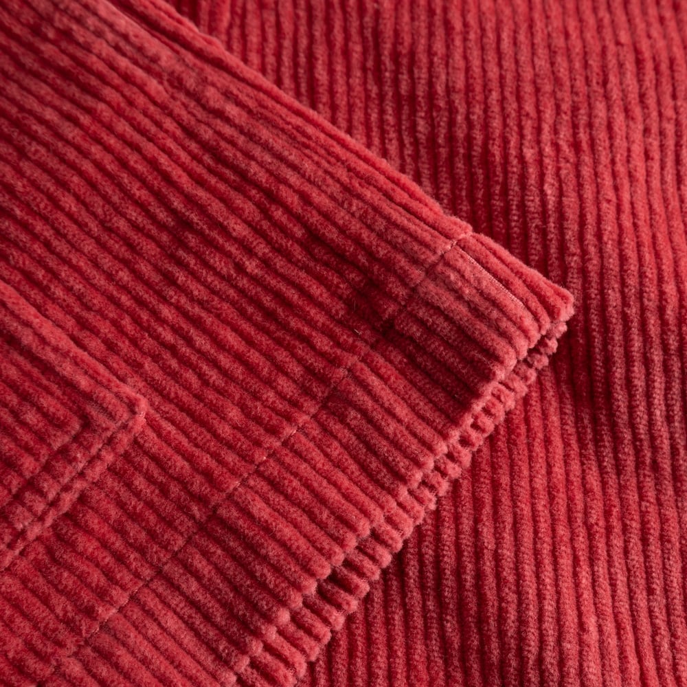 A close-up detail shot of the sleeve and cuff of the Holly Red corduroy Stiby Jacket, showing the fabric's texture.