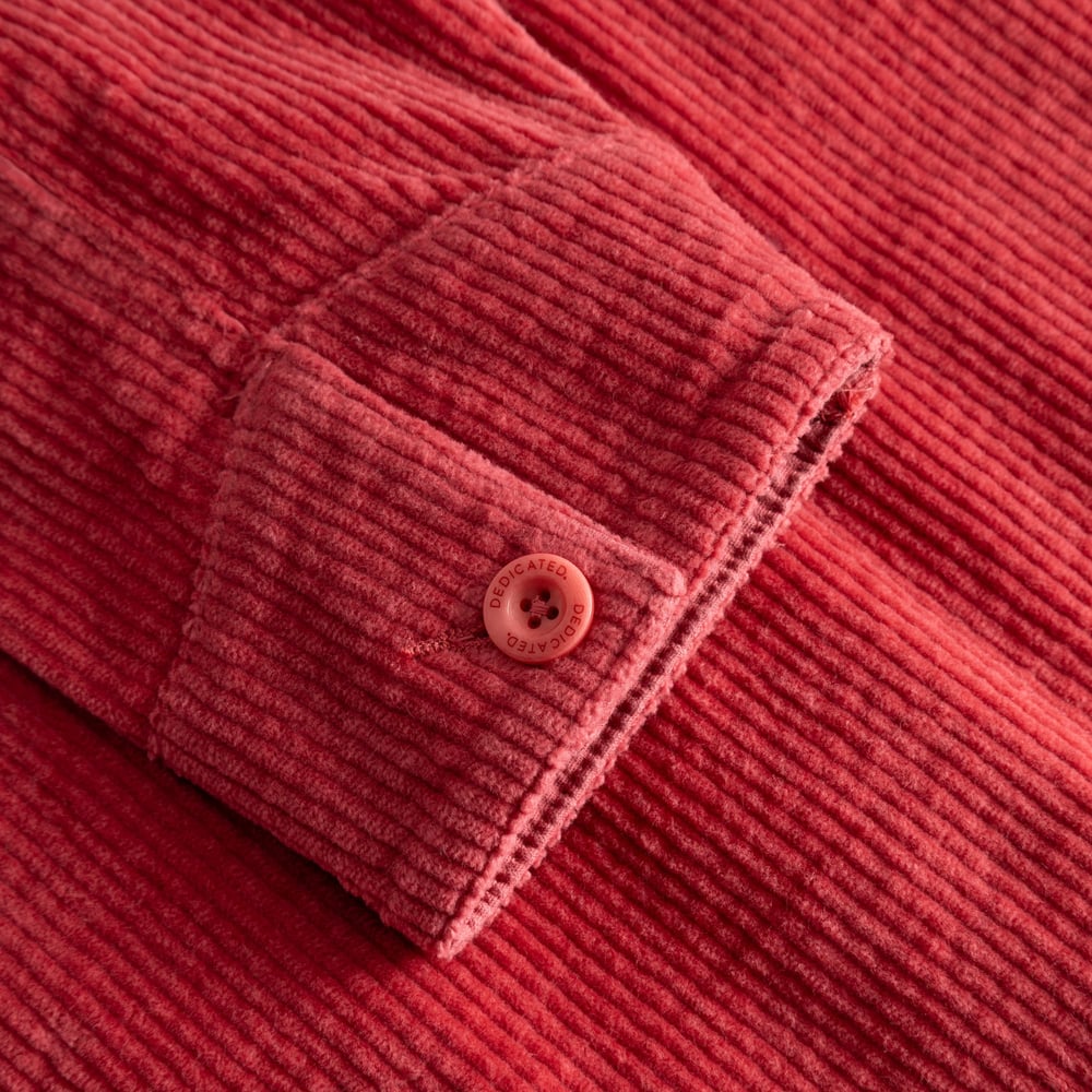 Close-up shot of the Holly Red corduroy sleeve on the Stiby Jacket, showing the cuff and branded button detail.