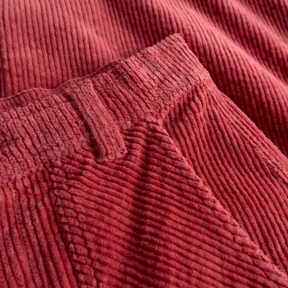 Close-up of the soft, ribbed corduroy fabric and waistband detail on the Vara Workwear Pants in Holly Red.