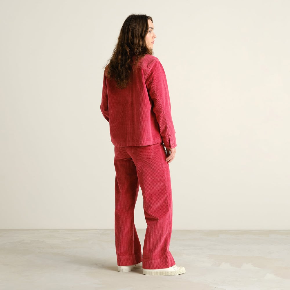 Model from behind shows the flattering wide-leg fit of the Vara Corduroy pants in Holly Red, styled with a matching jacket.