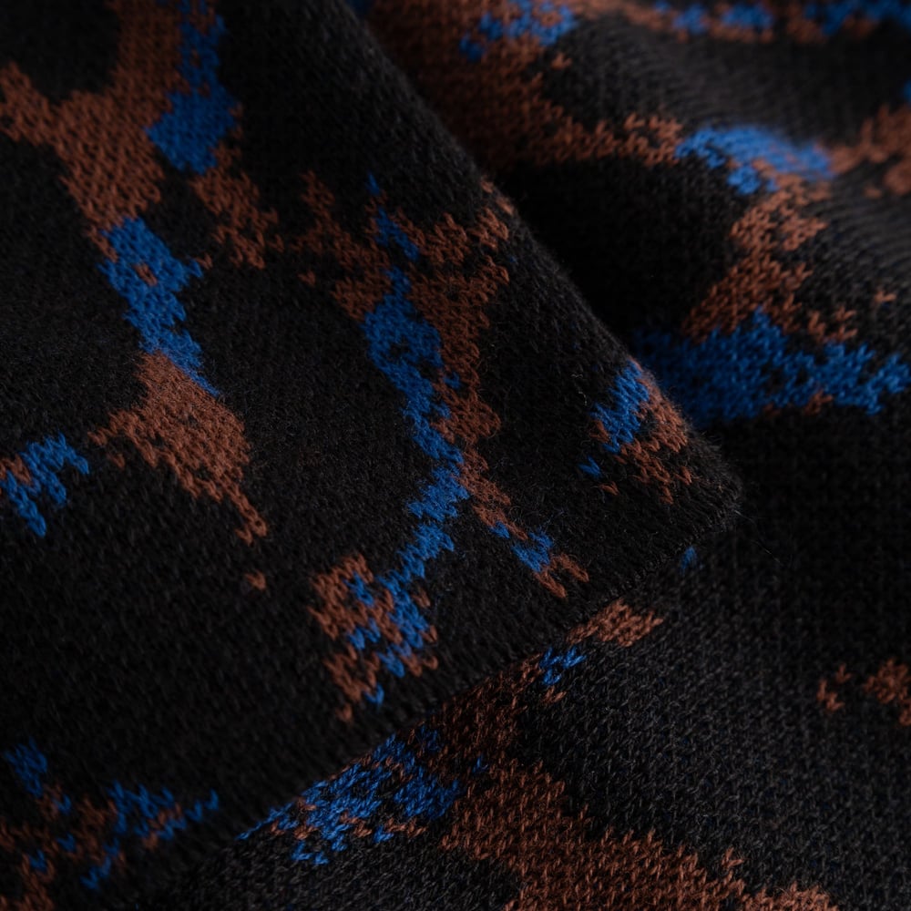 Close-up of the organic cotton jacquard knit on the Limhamn Sweater, featuring a bold leopard print in blue and brown.