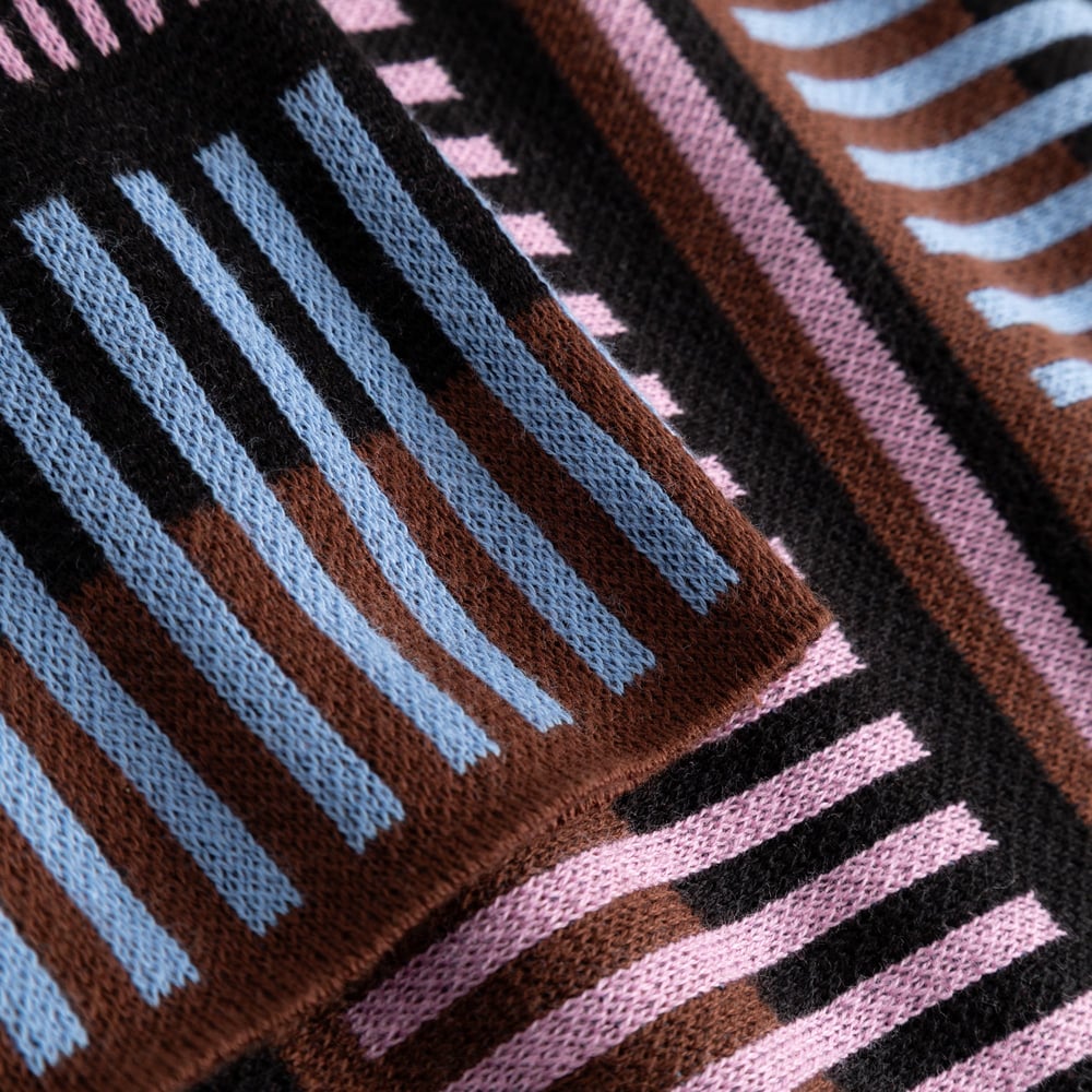 A close-up of the fine jacquard knit of the Sweater Limhamn, showcasing the multi-colored dashed stripe pattern.