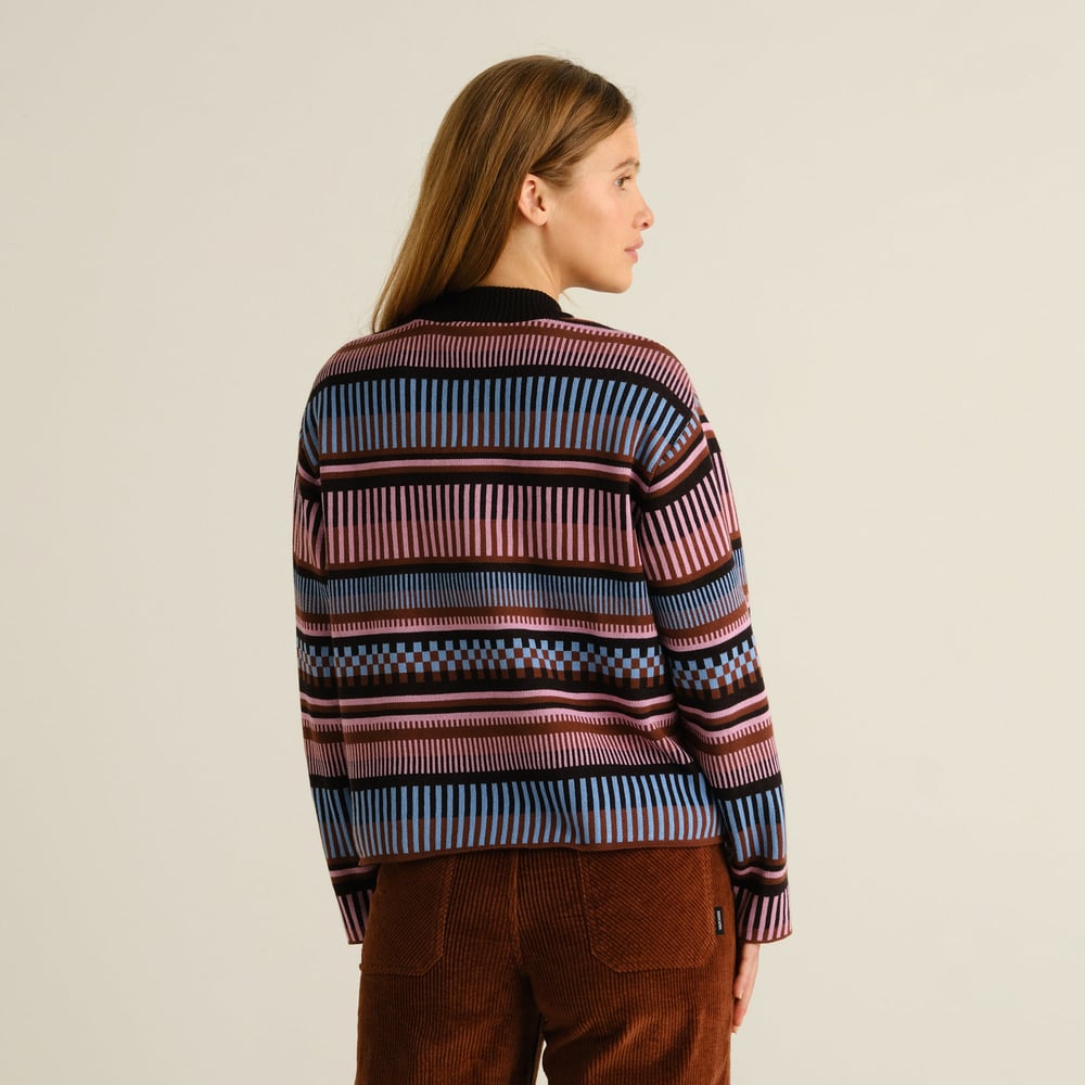 Model from behind wearing the multi-colored Sweater Limhamn Dashed Stripe paired with brown corduroy trousers.
