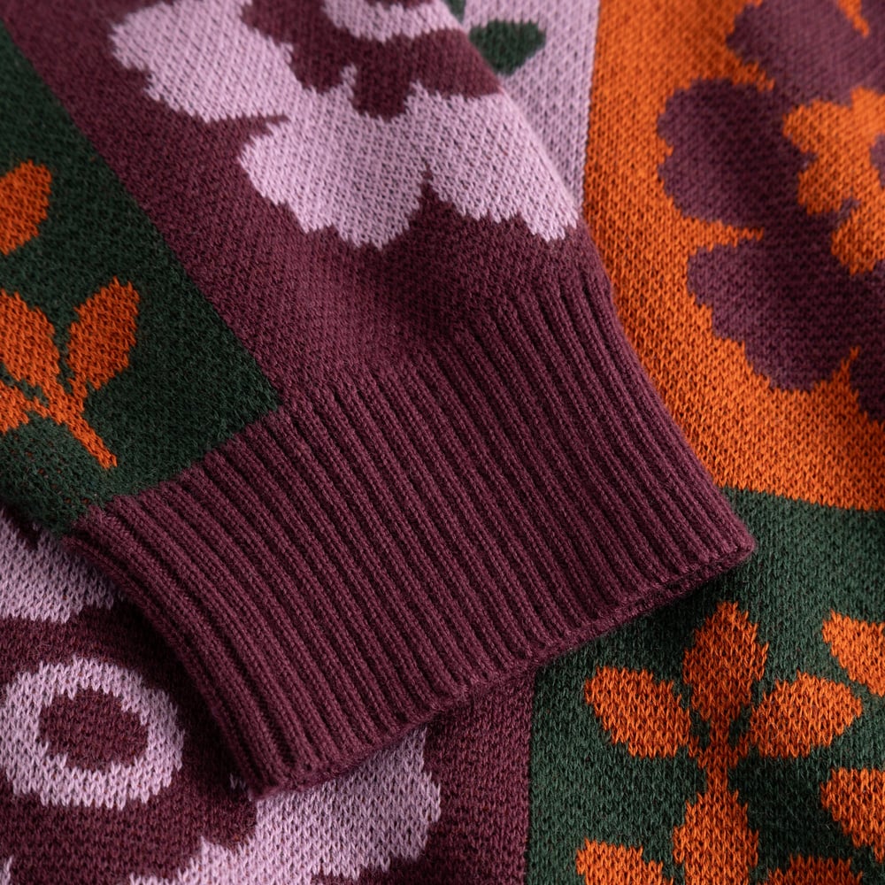 Detail shot of the Arendal sweater's cozy ribbed cuff, set against its vibrant, retro-inspired jacquard floral pattern.
