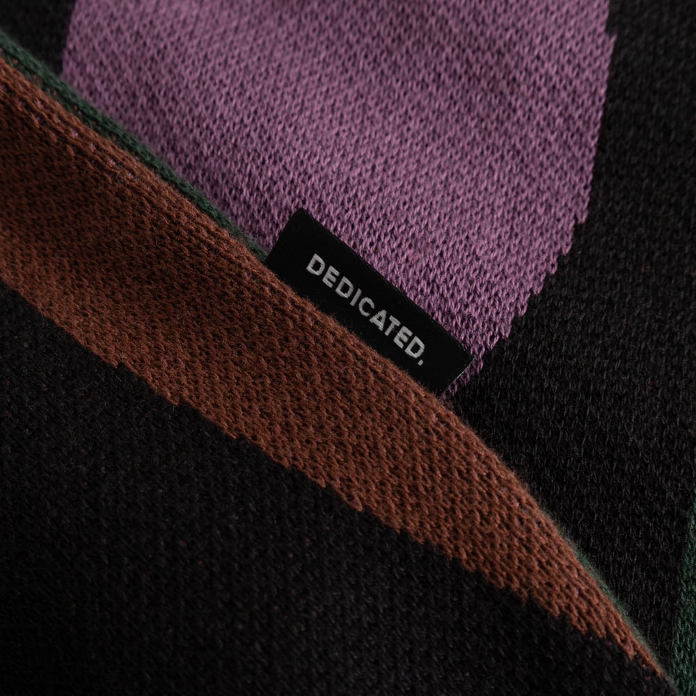 A close-up detail of the Sweater Arendal Wavy Stripe, showing the colorful knit and the classic Dedicated brand label.