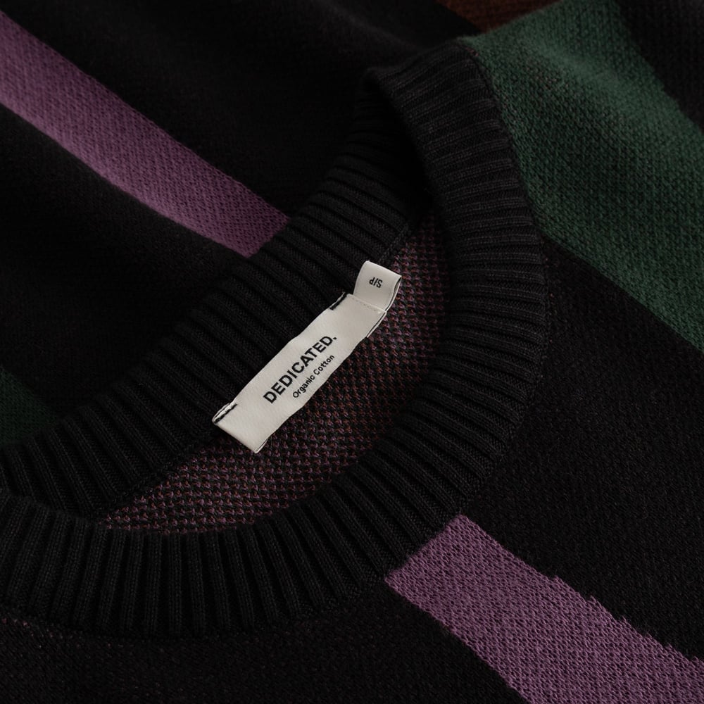 Close-up detail of the Arendal Wavy Stripe sweater, showcasing the organic cotton label and rich, colorful knit.