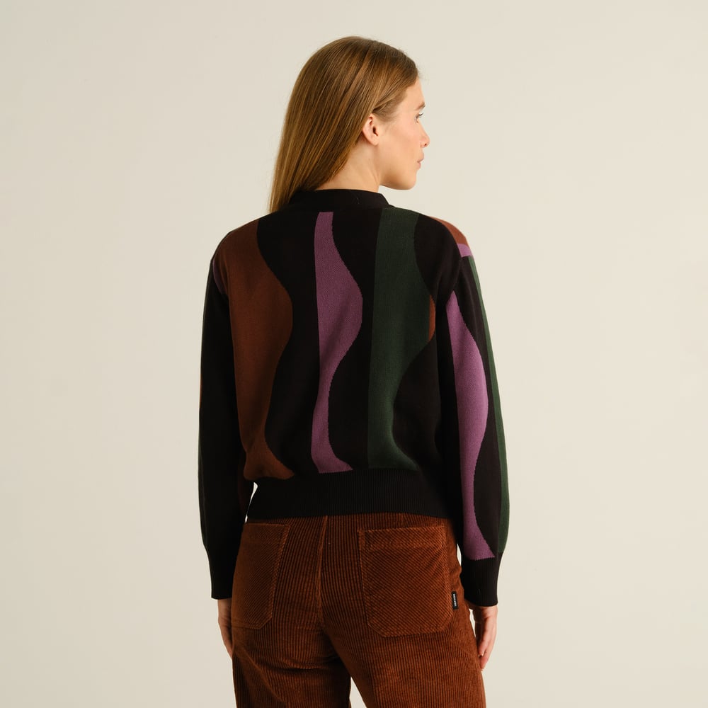Back view of the Cardigan Kanan Wavy Stripe Multi Color, styled by a woman with brown corduroy pants.