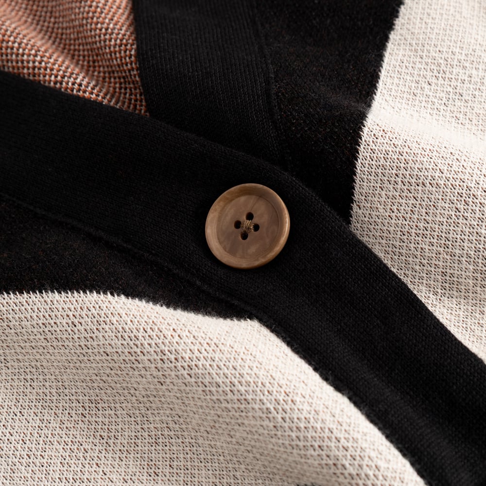A close-up of the Cardigan Kanan Western, highlighting the chunky button against the multi-colored jacquard knit.