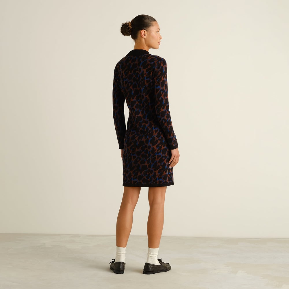 Model von hinten im Lo Kleid mit buntem Leopardenmuster, kombiniert mit weißen Socken und schwarzen Loafern.