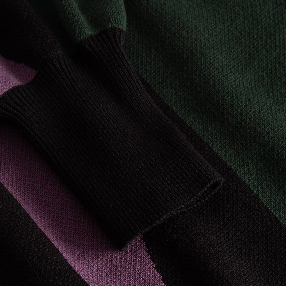 A detailed close-up of the multi-colored Dress Nikkala, focusing on the fine knit texture and the soft, black ribbed cuff.